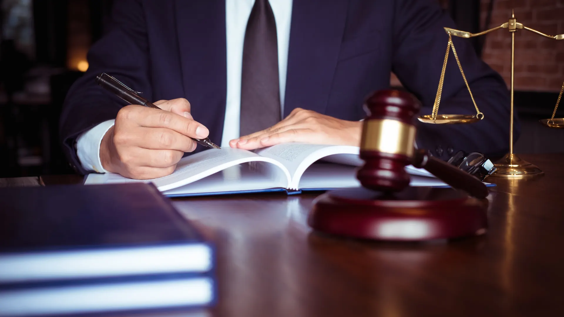 Estudo jurídico com livros, martelo e balança da justiça